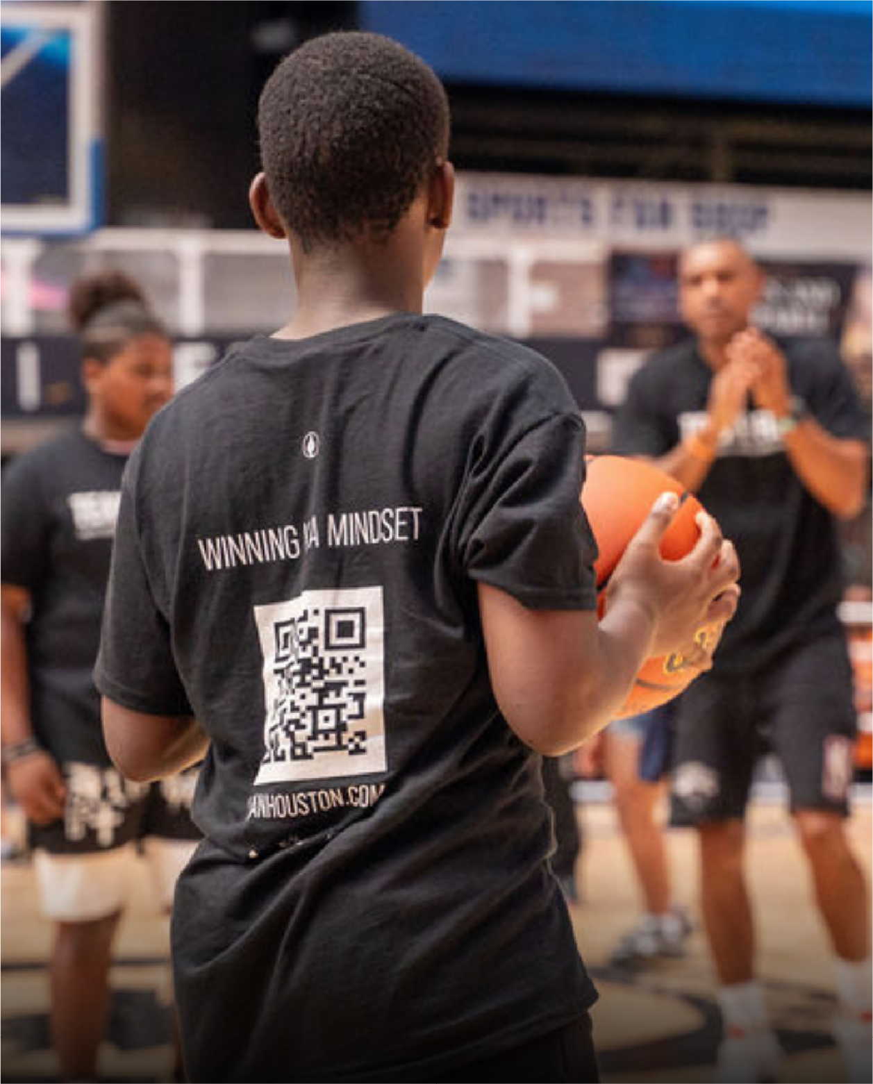 Young player holding a basketball at a Team FISLL session